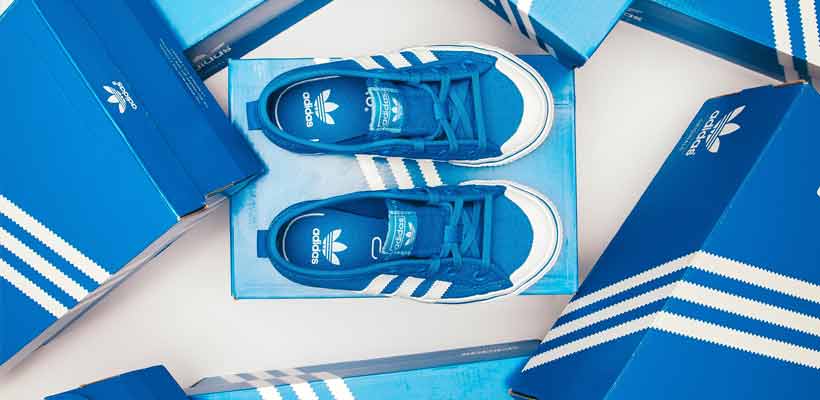 A pair of blue adidas trainers among cardboard boxes