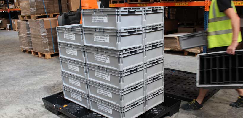 Warehouse operative stacking reusable plastic containers on a pallet