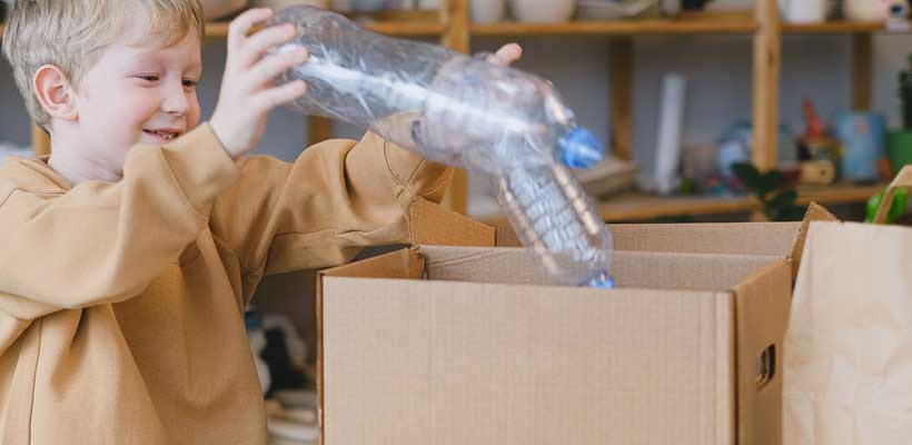 A young child holding recyclable packaging