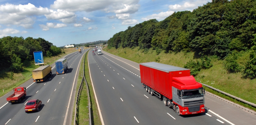 Red lorry driving down a motorway