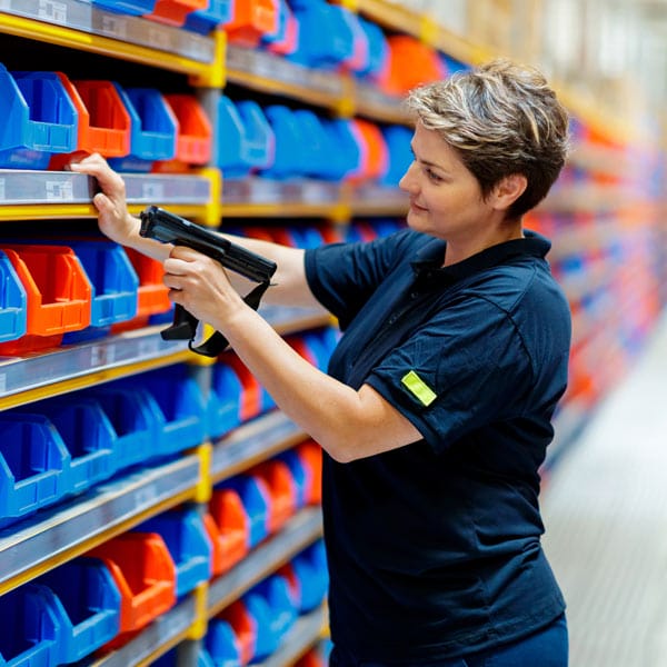 A person in a warehouse scanning picking bins