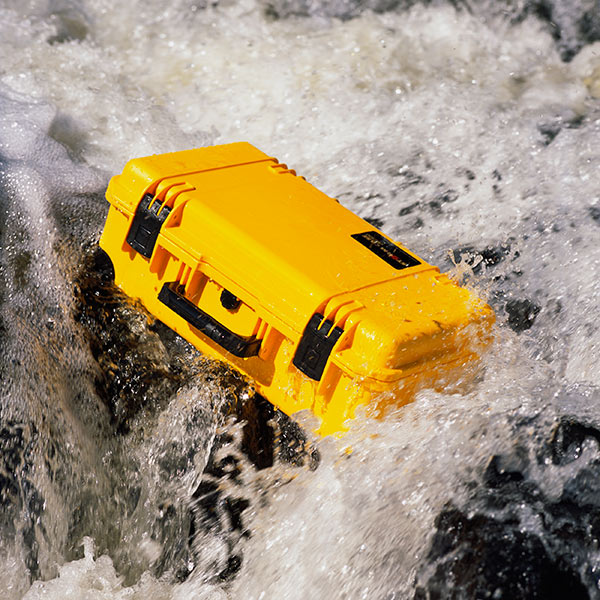 A yellow waterproof case in fast flowing water