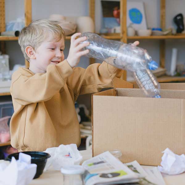 A young boy carrying recyclable packaging