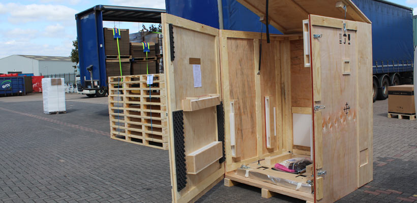 Large wooden shipping crate A large wooden shipping crate with open lid and door.