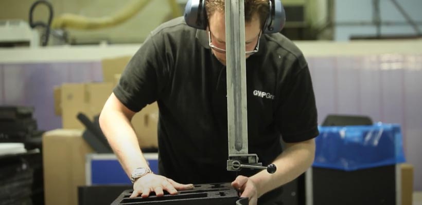 Foam cutting A person cutting foam with a band-saw
