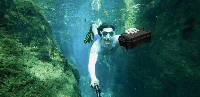 A diver underwater holding a Peli Ruck case