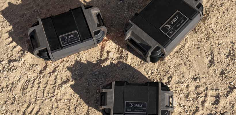 Three Pelican Ruck cases on a sandy floor