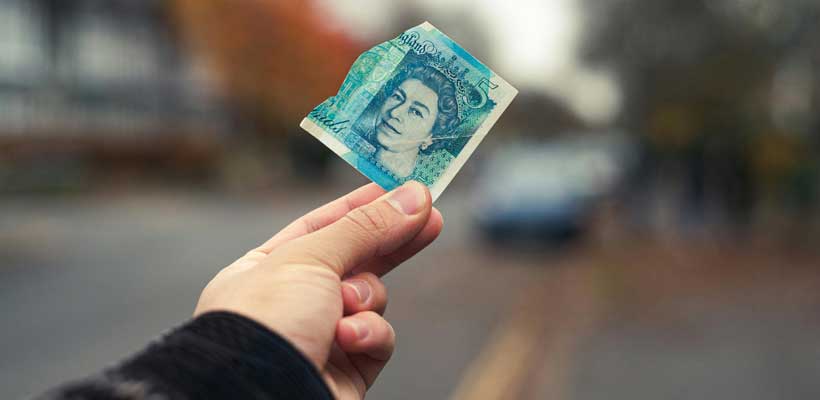 UK economy A person holding up a torn five pound note