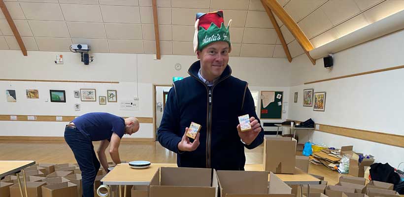 A Marmalade Trust volunteer filling the boxes with festive items.