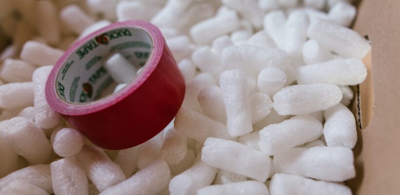 a red tape on a pile of white styrofoam packing peanuts