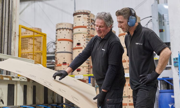 Two people inspecting cardboard packaging at GWP Group's factory