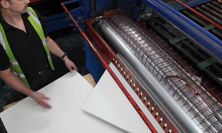 A person coating corrugated cardboard