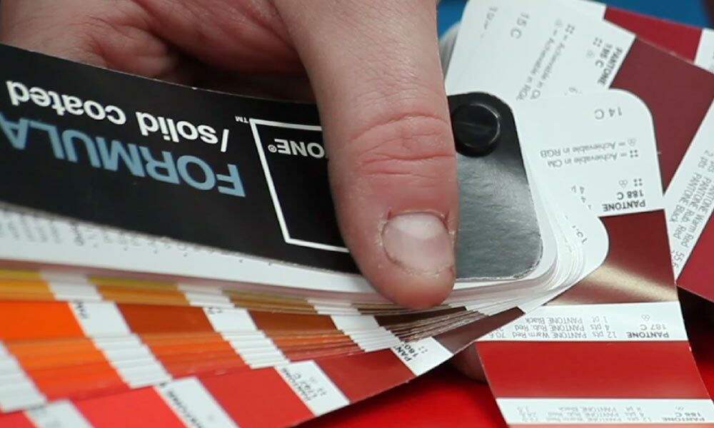 A person checking the colour of Pantone matched cardboard