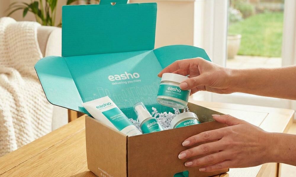 A person taking an eCommerce order out of a printed die cut box in their home