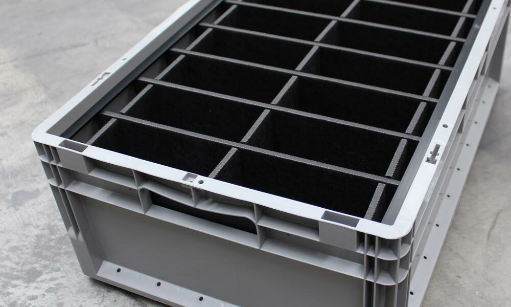 A Euro container with dividers on the floor of a warehouse