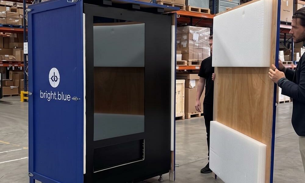RAL colour timber case A person unpacking a large product from a timber case painted in a RAL blue colour